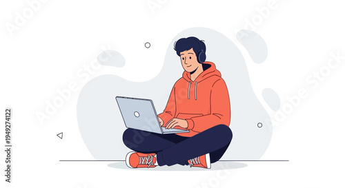 Young man with headphones using laptop and listening to music, sitting cross-legged on floor