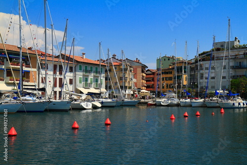 Sailboats moored in a vibrant waterfront town, Grado, Italy