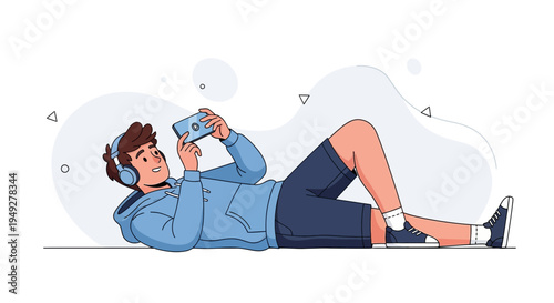 Young man lying down wearing headphones and playing on smartphone, casual style
