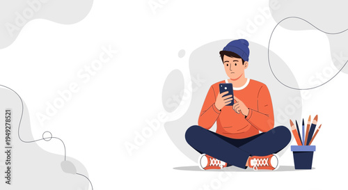 Young man sitting cross-legged, using smartphone, surrounded by art supplies.