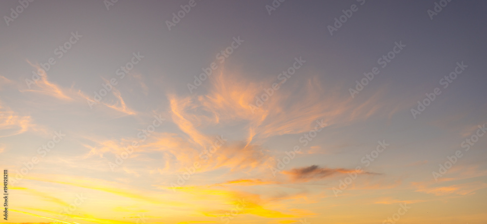 Obraz premium Breathtaking Vibrant Sunset Sky with Purple and Orange Pastel Clouds,A stunning twilight sky featuring a beautiful gradient of deep purple, soft pink, and vibrant orange. The scattered altocumulus.