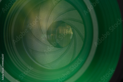Close-up of Professional Camera Lens Aperture with Green Optical Coating,Detailed macro shot of a camera lens diaphragm blades and aperture opening, featuring vibrant green multi-coating reflections.