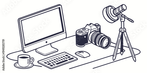 A professional workspace with a computer, camera, and coffee cup