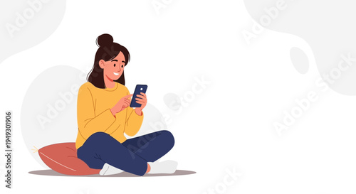 Young woman sitting cross-legged on a cushion, happily using her smartphone.