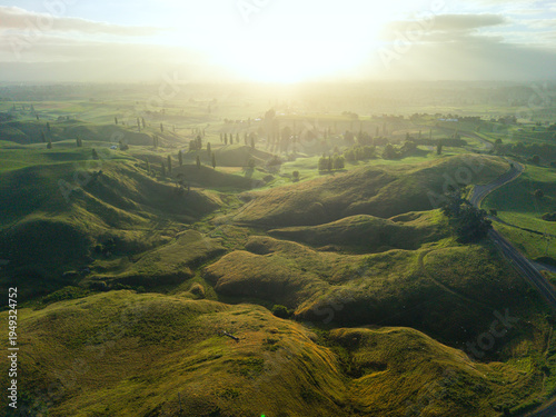 Drone aerial at sunrise over rolling hills of Hobbiton in New Zealand