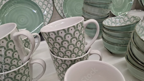 Stylish ceramic tableware in sage green and white. Mugs and bowls with delicate patterns for home decor, cozy kitchen interiors, modern lifestyle. Display of elegant dishes solid mint colors