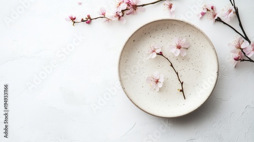 Delicate Cherry Blossoms Arranged on a Simple Plate in a Minimalist Setting D...