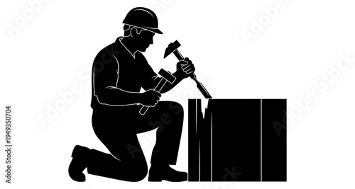 Silhouette of a construction worker kneeling and using a sledgehammer