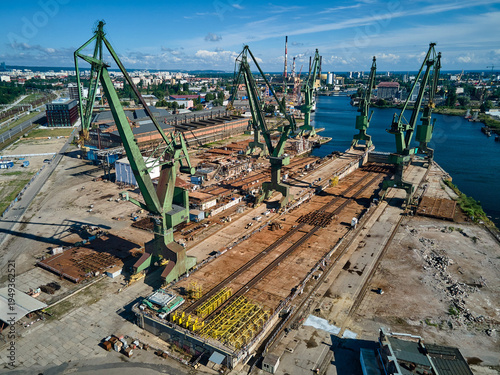Foto Wide aerial view of large industrial green cranes and shipyard infrastructure along the Martwa Wisla river, Gdansk Shipyard, Gdansk, Poland, Europe