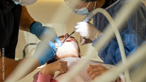 Canvas-taulu Female Patient Receiving Dental Treatment and Tooth Removal in Modern Dental Off