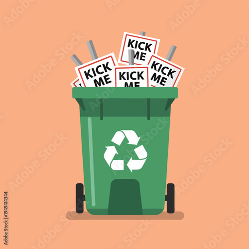 Green recycling bin overflowing with paper kick me signs on wooden sticks and trash can on orange background representing april fools pranks and jokes