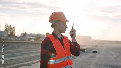 Professional builder talking with worker via radio set