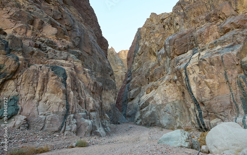 Dramatic landscape of canyon in lower Wadi Isla, Saint Katherine Protectorate in Egypt. A deep, narrow and rugged canyon. High cliffs and steep granite walls. Red, green, black colors of magmatic rock