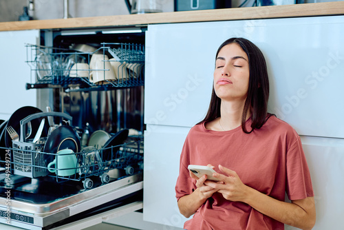 Bild auf Leinwand Woman feeling tired and overwhelmed by household chores, leaning against kitchen