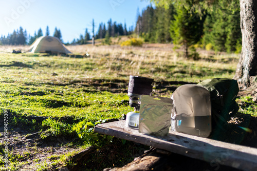 Hiker preparing freeze-dried meal in a mountain camp with tent.
