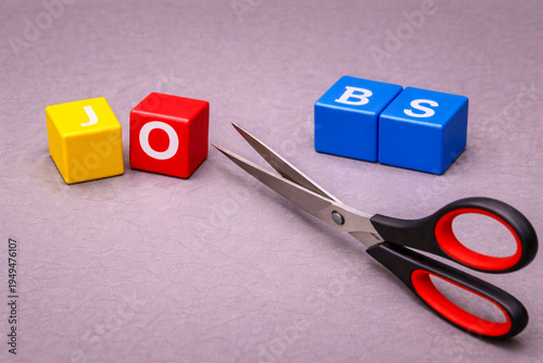 a symbolic economic scene made with colorful letter cubes and a pair of scissors.  companies are cutting jobs, Companies reducing workforce
Economic slowdown affecting employment