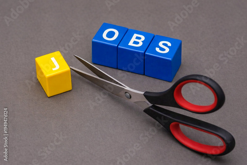 a symbolic economic scene made with colorful letter cubes and a pair of scissors.  companies are cutting jobs, Companies reducing workforce
Economic slowdown affecting employment