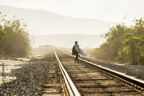 Teenager walking on train tracks