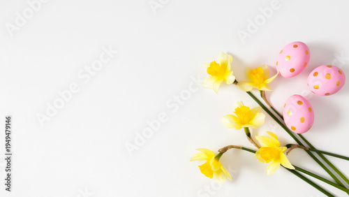 Easter Background with Yellow Daffodils and Pink Eggs with Gold Dots on White. Spring Floral Composition, Minimalist Narcissus Bouquet, Festive Greeting Card Flat Lay with Copy Space.