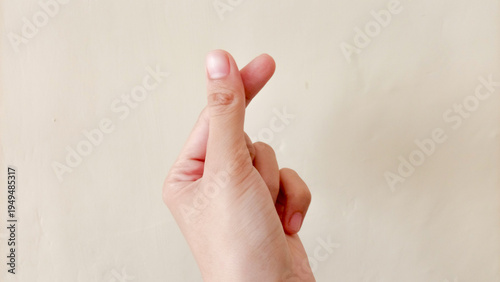 Tableau sur toile A woman's hand is making a heart hands or love hands gesture, with her index finger and thumb touching, against a plain background