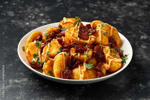 Patatas bravas with chorizo and sauce. Spanish traditional food