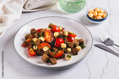 A mixture of tomatoes, cheese and rye croutons on a plate on the table