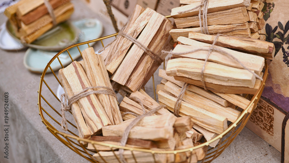 Obraz premium Palo santo wood bundles filling a golden basket at India Day in Moscow
