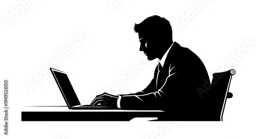Silhouette of a businessman working on a laptop at a desk in a modern office
