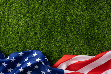 American flag resting on fresh green grass evokes patriotic feeling for Independence Day, Memorial Day, Veterans Day and Flag Day backgrounds and promotional use