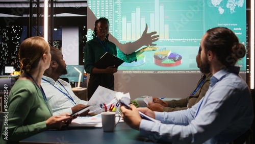 Foto Black team leader from a corporation discussing financial details and insights in a new project presentation during late night business meeting