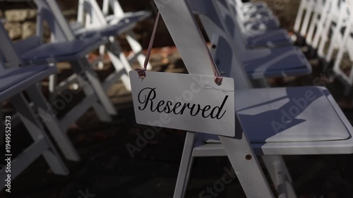 Reserved Sign on White Folding Chairs at Outdoor Wedding