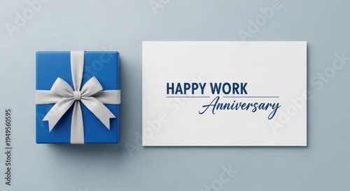 Blue gift box with white ribbon next to card reading happy work anniversary, for employee appreciation, corporate recognition, professional milestone achievement