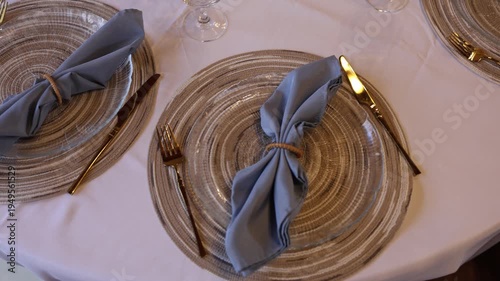 Elegant table setting with blue napkins and gold cutlery