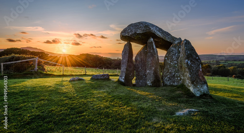 Valokuva Pentre Ifan Neolithic burial chamber at sunset, surrounded by lush green fields