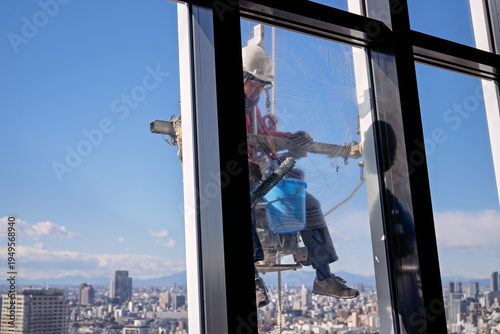 фотографія Window Cleaner on High‑Rise with Soap‑Covered Glass – Safety Gear & Urban Textur