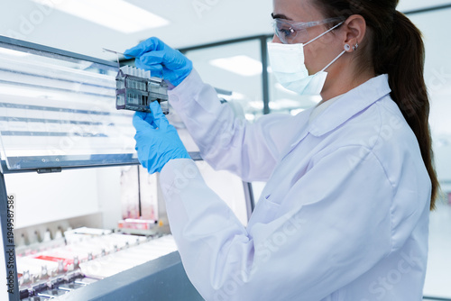 Photos Medical scientist loading slide rack into automated stainer machine