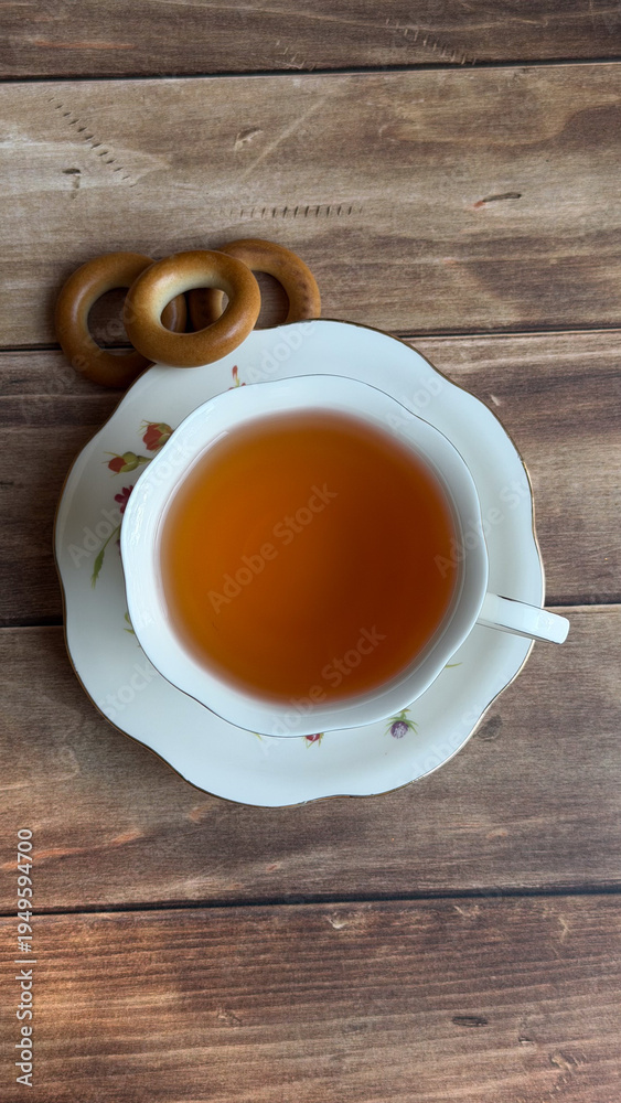 Obraz premium Overhead teacup filled with tea on wooden table surface