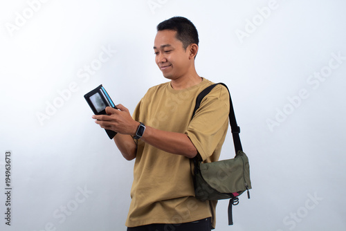 Man holding wallet in front of white background.