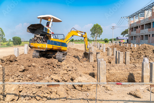 Backhoe digging soil for foundation work at a building construction project.