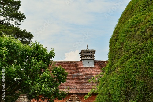 Dovecote on the red tiled roof against blue sky, West Midlands, England, UK