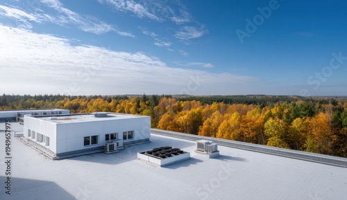 Modern commercial flat roof with air conditioning units and cooling systems overlooking a colorful autumn forest