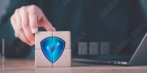 Cybersecurity specialist implementing data protection strategy with shield security icon on wooden blocks, ensuring compliance, risk management, privacy protection and secure digital infrastructure