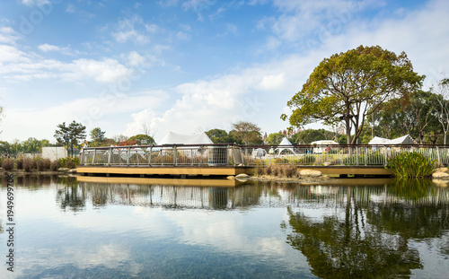 Tranquil Park Landscape with Reflections and Tents in Background