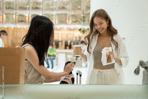 Women friends enjoying coffee with pet dog in cafe