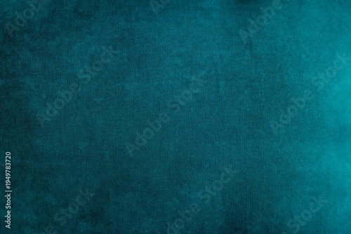 A close-up view of a textured teal fabric. The surface displays a soft, smooth finish with subtle variations in color and light.
