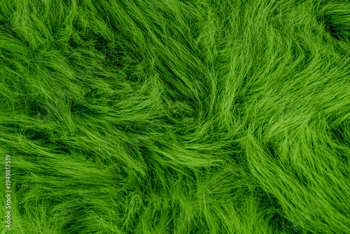 Slika na platnu Vibrant green fluffy faux fur textile background with long soft wavy flowing fib