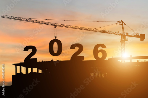 Silhouette of construction camp site with cranes building construction prepare to welcome the new year 2026 at sunset.