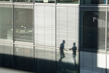 Shadow of two businessmen on a sunblind