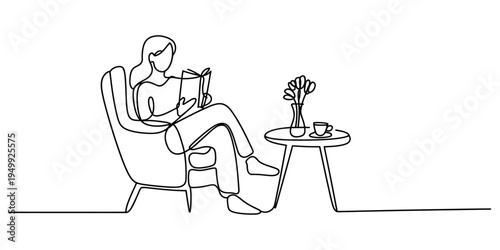 A woman sitting in a cozy armchair reading a book with a cup of coffee on a side table.