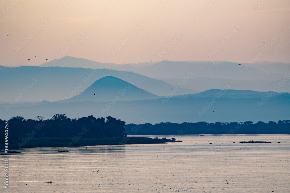 Naklejka premium Serene misty mountains and river at sunset